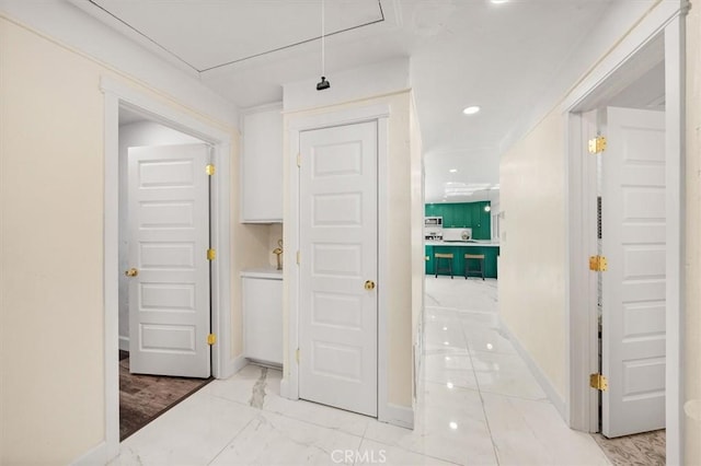 hallway with attic access, recessed lighting, marble finish floor, and baseboards