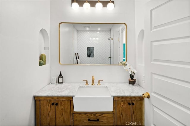 bathroom featuring a shower and vanity