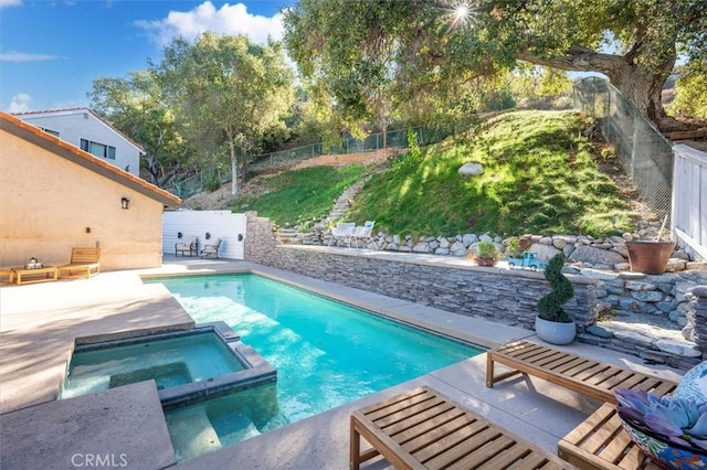 view of swimming pool featuring a patio area, a fenced backyard, and a pool with connected hot tub