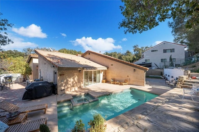 back of house with a patio, stucco siding, a pool with connected hot tub, fence, and a tiled roof