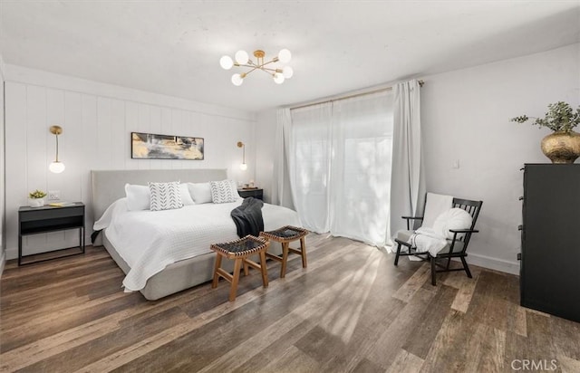 bedroom with a chandelier, dark wood-style flooring, and baseboards