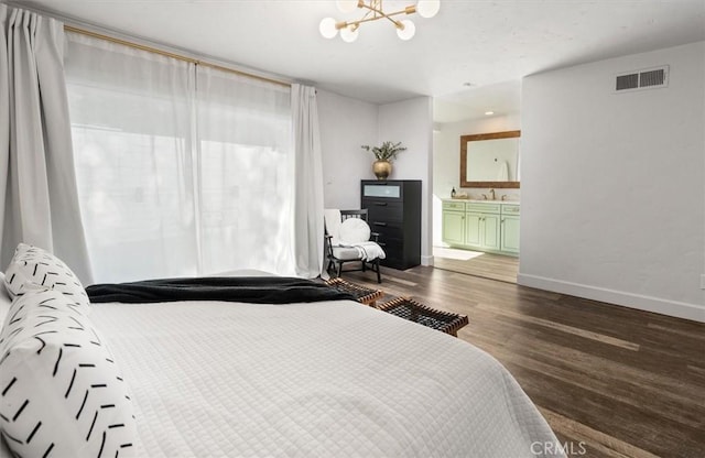 bedroom featuring a chandelier, ensuite bathroom, visible vents, baseboards, and dark wood finished floors