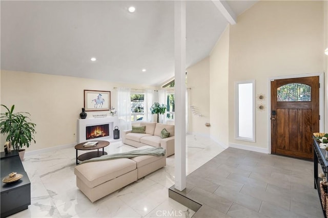 living area featuring marble finish floor, recessed lighting, high vaulted ceiling, a warm lit fireplace, and baseboards