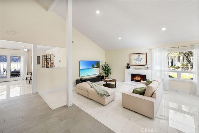 living room featuring a warm lit fireplace, baseboards, marble finish floor, and high vaulted ceiling