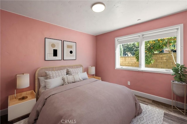 bedroom featuring wood finished floors and baseboards