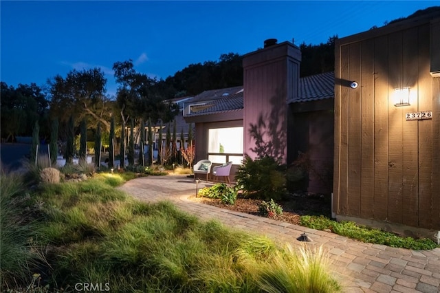 view of side of home featuring a patio area and a chimney