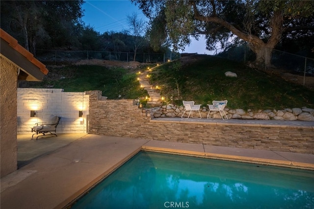 view of swimming pool featuring fence, a fenced in pool, and a patio