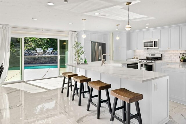 23726 La Salle Canyon Rd, Newhall, CA 91321 - kitchen with stainless steel appliances, light marble finish flooring, backsplash, a center island with sink, and light stone countertops