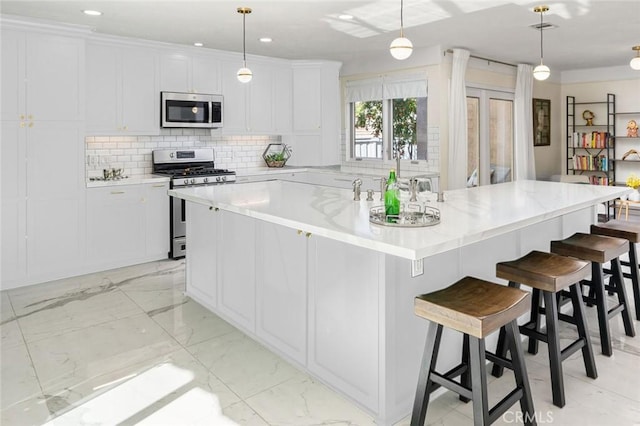 23726 La Salle Canyon Rd, Newhall, CA 91321 - kitchen with appliances with stainless steel finishes, a large island, backsplash, white cabinetry, and pendant lighting