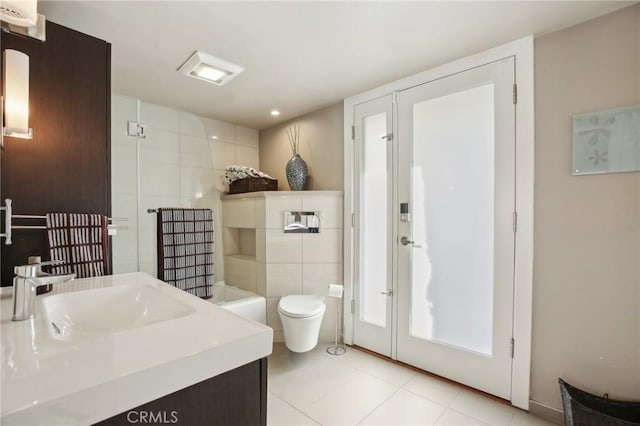 bathroom featuring walk in shower, tile patterned floors, toilet, tile walls, and vanity