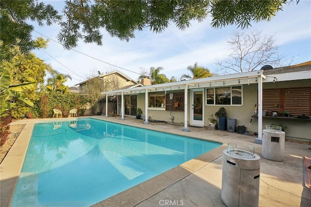 view of pool with a fire pit and a patio