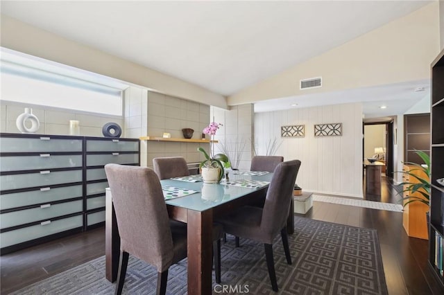 dining area featuring dark wood-type flooring and vaulted ceiling