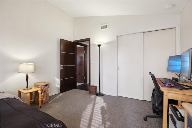 bedroom with lofted ceiling, a closet, and dark colored carpet