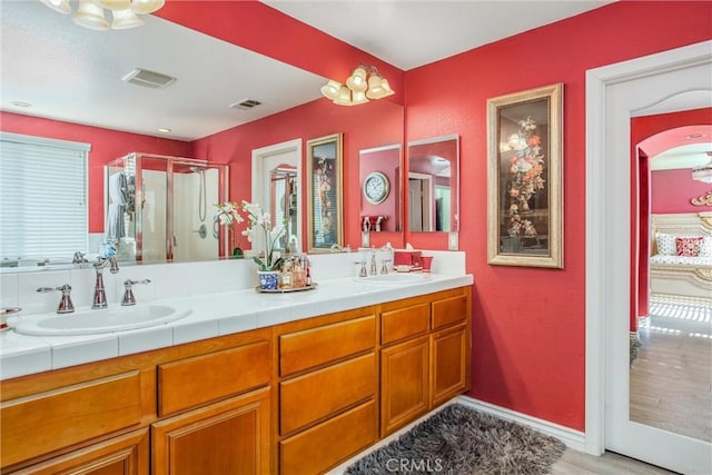 bathroom with vanity, an enclosed shower, and wood-type flooring