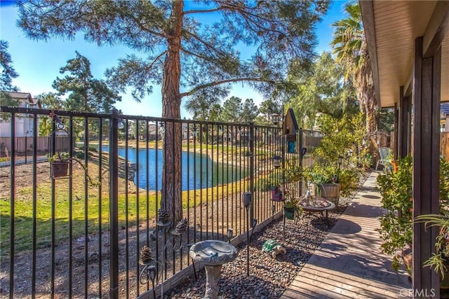 view of gate featuring a pool and a water view