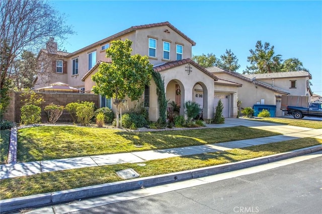 mediterranean / spanish home with a garage and a front yard