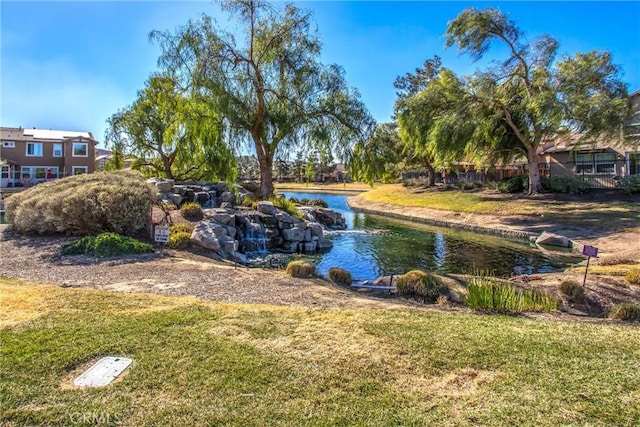 view of community featuring a water view and a lawn