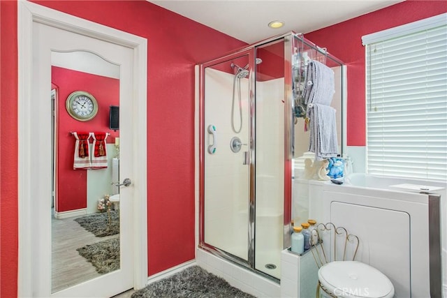 bathroom featuring washer / dryer and a shower with shower door