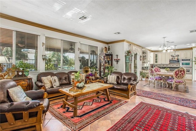 living room with an inviting chandelier, light tile patterned floors, and crown molding