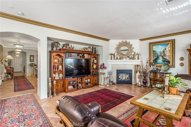 tiled living room featuring crown molding and a fireplace