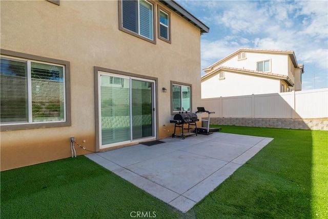 back of house featuring a patio area and a lawn