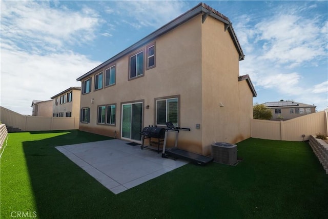 back of property with a yard, a patio area, and central AC