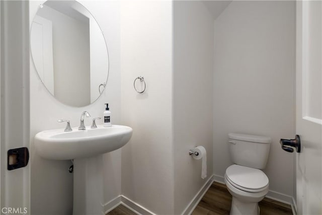 bathroom with toilet and hardwood / wood-style floors