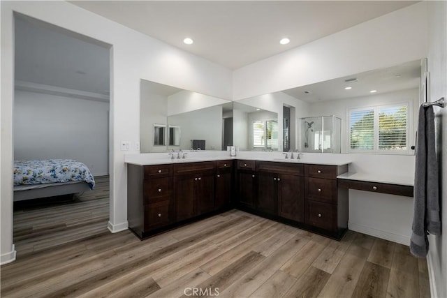 bathroom featuring hardwood / wood-style flooring, vanity, and walk in shower