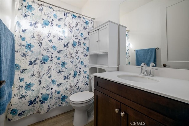 bathroom featuring vanity, wood-type flooring, toilet, and walk in shower