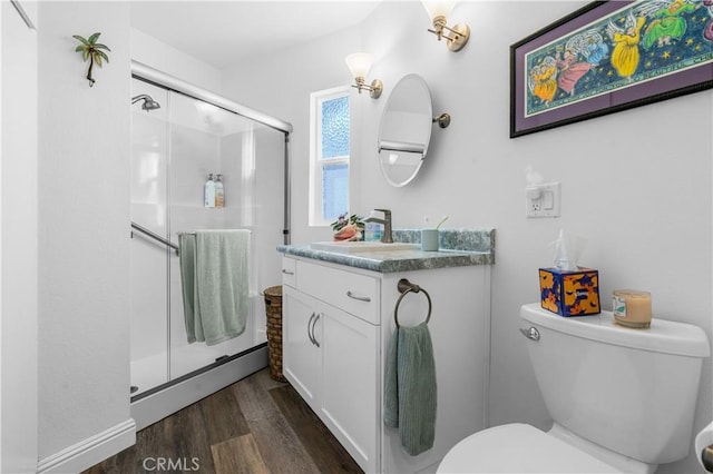 bathroom with wood-type flooring, toilet, a shower with door, and vanity