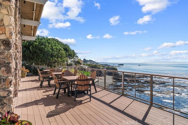 wooden deck featuring a water view and a view of the beach