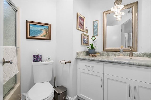 full bathroom featuring vanity, shower / bath combination with glass door, and toilet