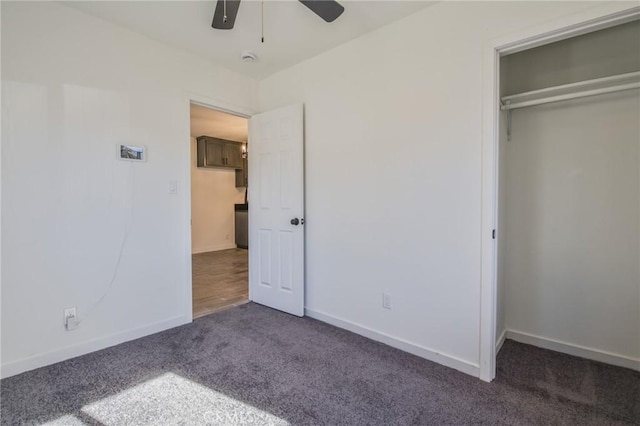 unfurnished bedroom featuring dark carpet, a closet, and ceiling fan