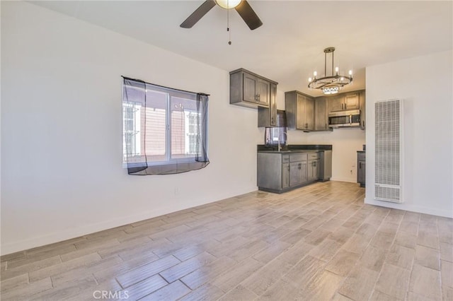 kitchen with hanging light fixtures and ceiling fan with notable chandelier