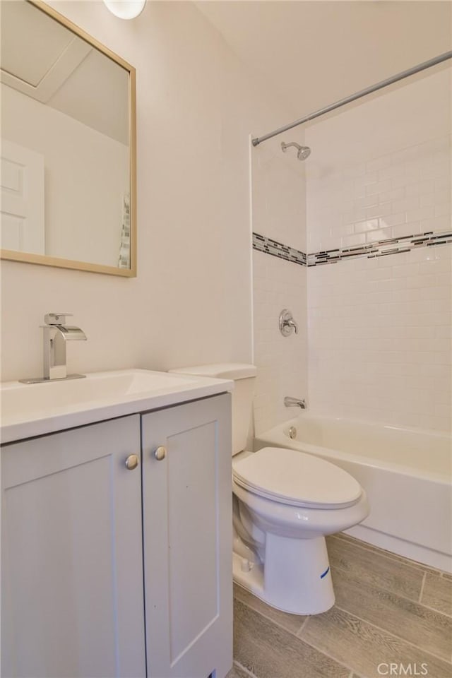 full bathroom featuring tiled shower / bath combo, vanity, and toilet