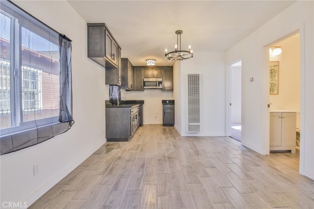 kitchen featuring a notable chandelier, decorative light fixtures, light hardwood / wood-style flooring, and sink