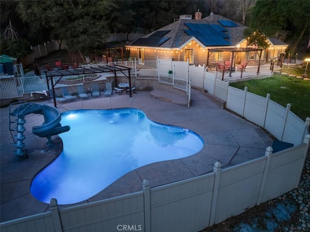 view of swimming pool featuring a water slide and a patio