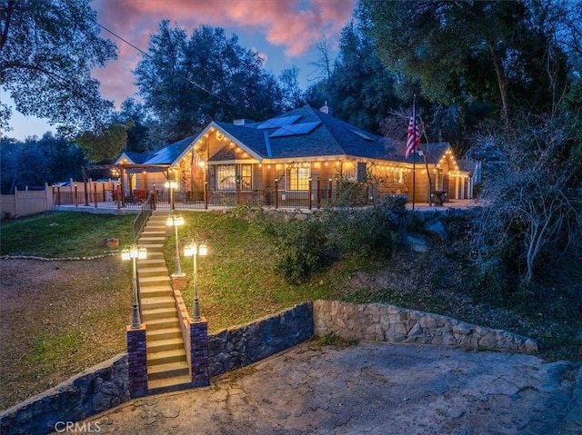 back house at dusk with a yard and covered porch