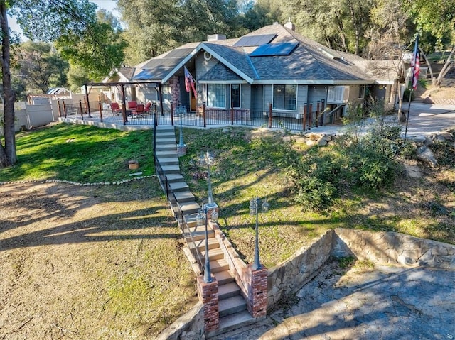 bungalow-style home with a front yard, a patio area, and solar panels