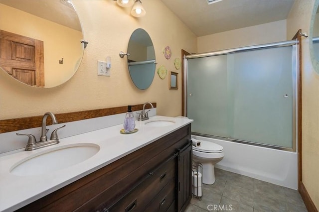 full bathroom featuring toilet, vanity, and shower / bath combination with glass door