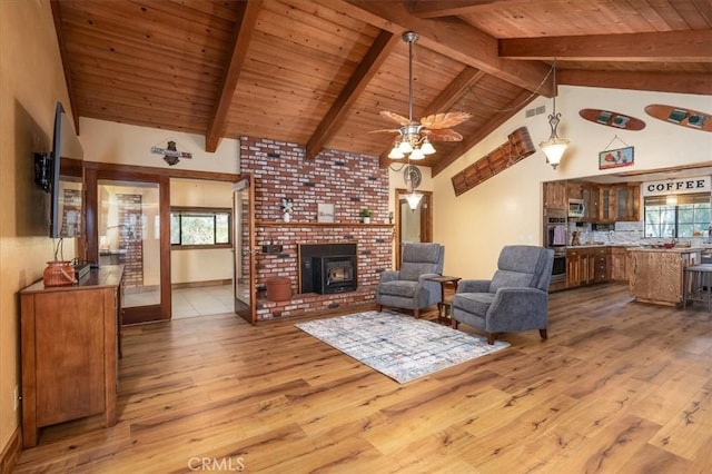 living room featuring beam ceiling, a wealth of natural light, wood ceiling, and light hardwood / wood-style floors