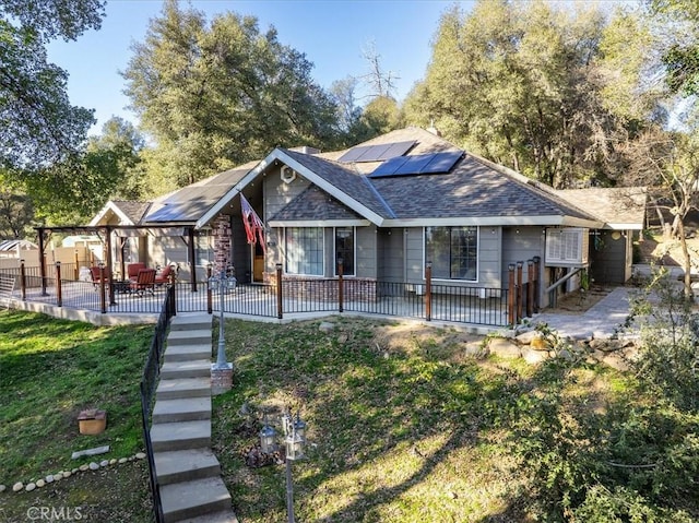 rear view of house featuring a yard, a patio area, and solar panels