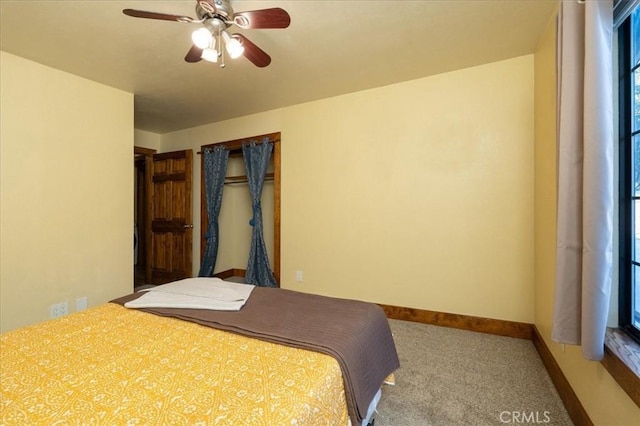 carpeted bedroom with ceiling fan and a closet