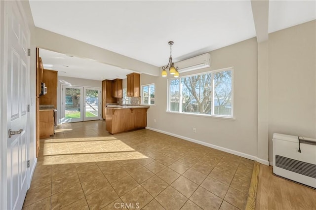 kitchen with pendant lighting, light tile patterned floors, a wall mounted air conditioner, a notable chandelier, and kitchen peninsula