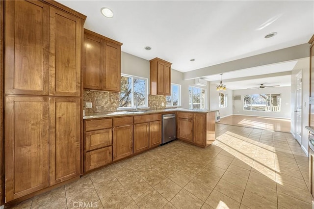 kitchen featuring plenty of natural light, sink, stainless steel dishwasher, and backsplash