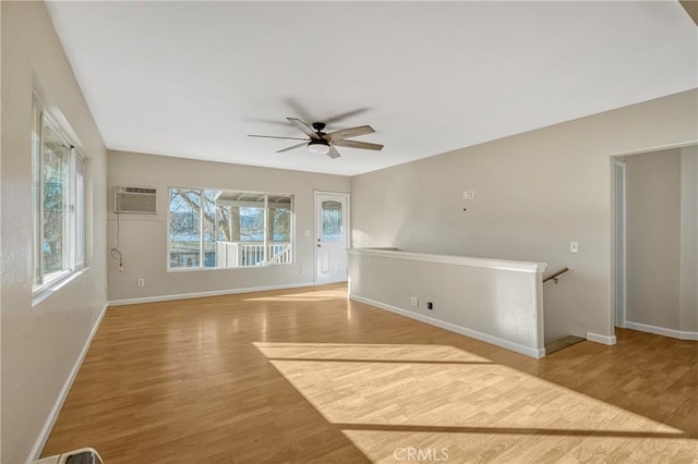 unfurnished room featuring hardwood / wood-style flooring, ceiling fan, and a wall unit AC