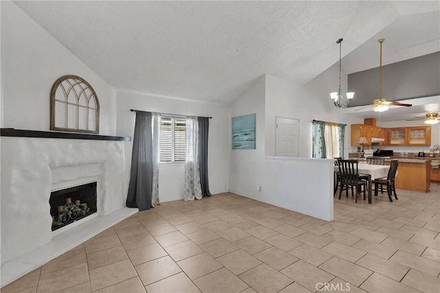 tiled living room with ceiling fan with notable chandelier, vaulted ceiling, and a textured ceiling