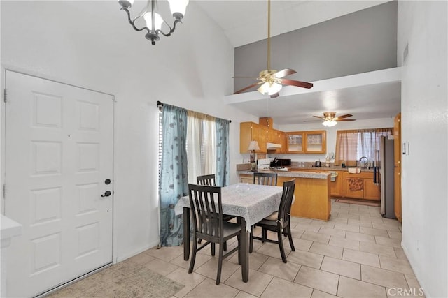 dining area with light tile patterned flooring, a chandelier, and high vaulted ceiling