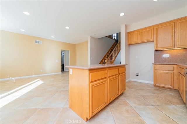 kitchen with light tile patterned flooring, decorative backsplash, and a kitchen island