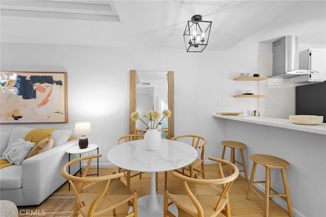 dining space with an inviting chandelier and light hardwood / wood-style flooring